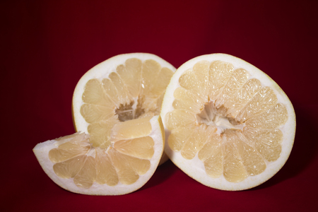 Cut pomelo on a red backgroundの写真素材