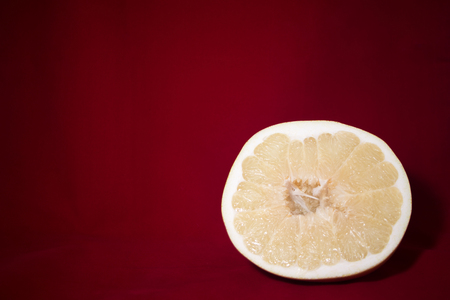 Cut pomelo on a red backgroundの写真素材