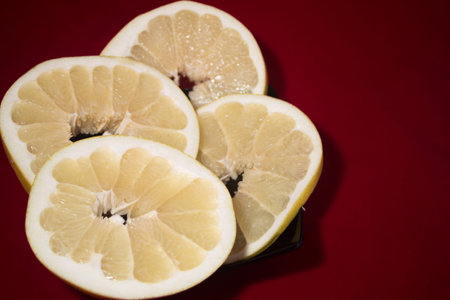 Sliced pomelo on a black plate