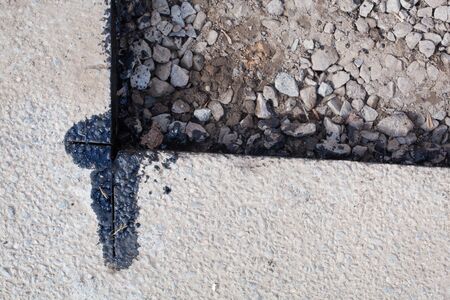 Destroyed asphalt cover on road. Bad road condition that needs repair. Theme of road construction and repairの写真素材