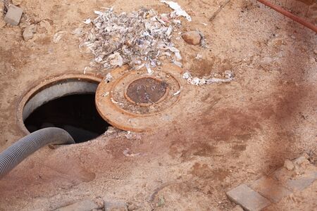 pumping sewage through a specialized hose from an open manholeの写真素材