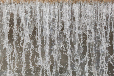 City river waterfall large cascade wall close-up on a summer day, side view of the falling water...