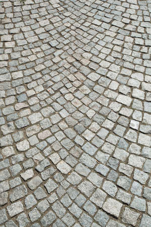 Stone pavement texture. Granite cobblestoned pavement background. Abstract background of old cobblestone pavement with shallow depth of fieldの写真素材