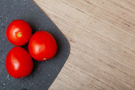 Top view of three red ripe tomatoes on plastic board lying on the table. menu conceptの写真素材