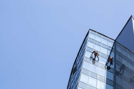 industrial climbers clean dirty windows of high-rise buildingsの写真素材