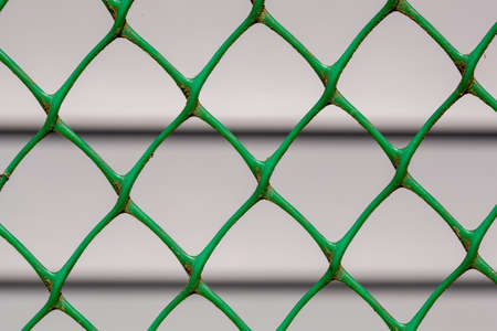Farmhouse made of siding through the chain-link fence that is in focusの写真素材