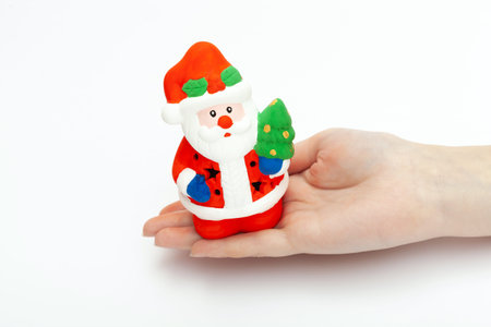 Little Santa Claus toy on the womans hand isolated on white background. christmas and new year...