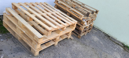 Wooden pallets for cargo transportation lying on the asphalt