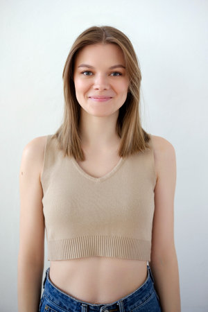 Young girl model snap in beige top t-shirt front look portrait view on white background.