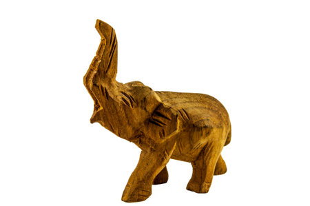 Elephant with a raised trunk carved out of wood isolated on background whiteの写真素材
