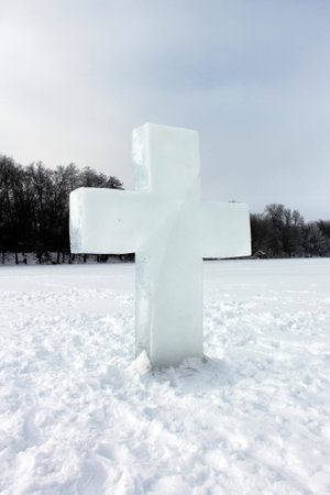 cross of ice on the river against the background of the forest in winterの写真素材