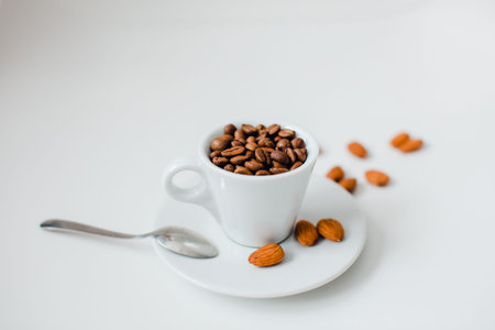 a cup filled with almonds, breakfast cereal and coffeeの写真素材