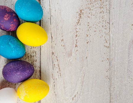 Colored easter eggs on wooden white shabby backgroundの写真素材