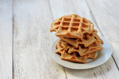 Stack of healthy oat waffles on plate with white wooden backgroundの写真素材