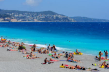 View of the beach in Nice, France, near the Promenade des Anglais. tourists, sunbeds on summer hot day, blurredの写真素材