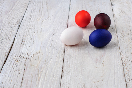 Colored easter eggs in line on wooden white shabby backgroundの写真素材