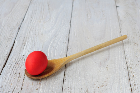 Colored easter eggs in spoon on wooden white shabby backgroundの写真素材