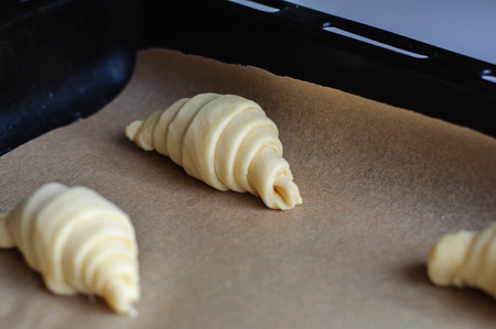 Not baked croissants on oven-trayの写真素材