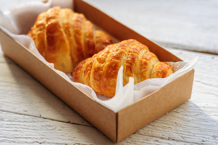 Breakfast with fresh baked croissants, butter on white wooden backgroundの写真素材