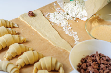 Croissants making on white table with flour and baking paper