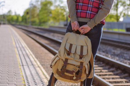 Legs of girl waiting train on train station with backpackの写真素材
