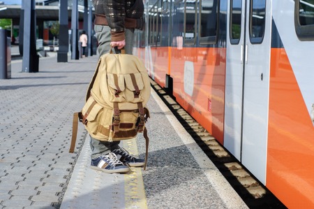 Young tourist man on railway platform near train doorsの写真素材
