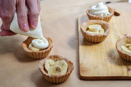 Cooking of little homemade oat tarts with whipped creamの写真素材