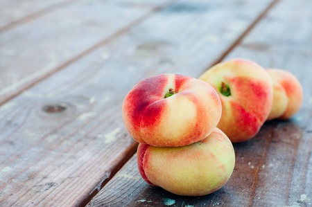 Fresh Saturn peaches on old wooden backgroundの写真素材