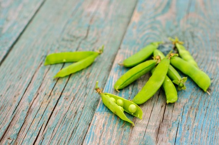 Ripe fresh green peas in pod on shabby wooden backgroundの写真素材