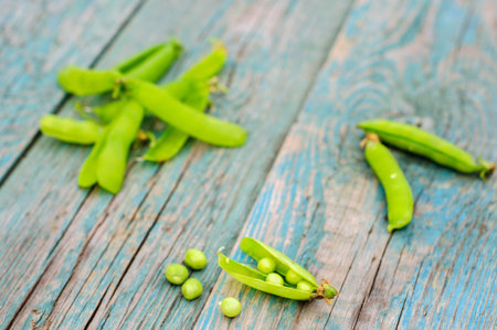 Ripe fresh green peas in pod on shabby wooden background