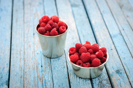 White enamel can and mug with fresh raspberryの写真素材