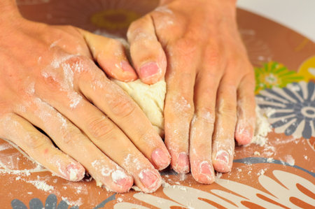Man hands making dough for homemade dumplings with meat