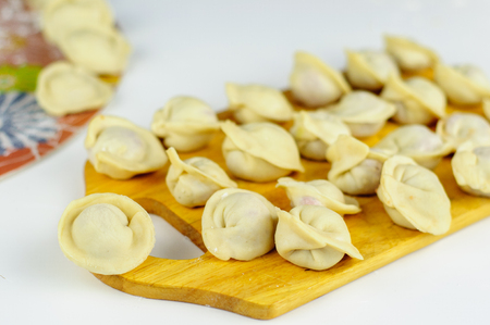 Raw homemade dumplings with meat on tableの写真素材