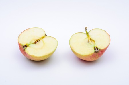 Chopped red yellow apple isolated on white backgroundの写真素材