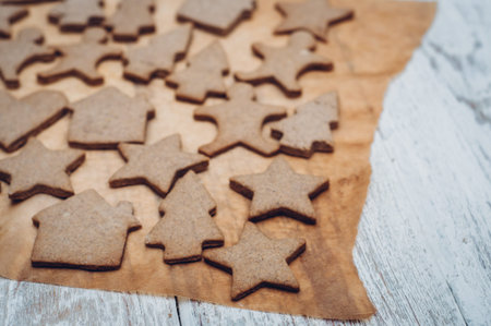 Christmas ginger cookies on white background and baking paper
