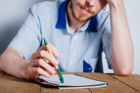 Young man writing notes in notebookの写真素材