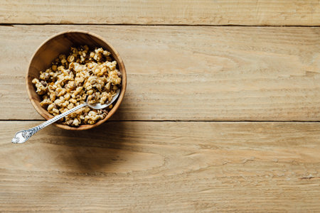 Homemade oatmeal granola in wooden bowl, flat layの写真素材