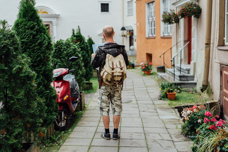 Young man traveler looking city map on streetの写真素材