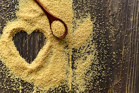 Wooden spoon with amaranth seeds and drawned heart with seedsの写真素材