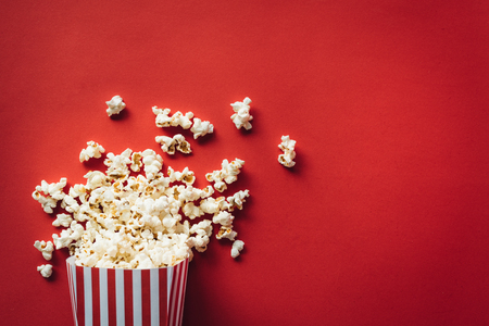 Striped box with popcorn on red backgroundの写真素材