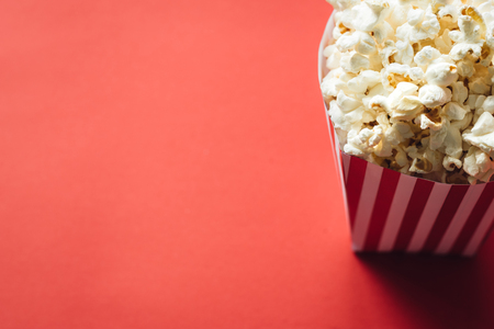 Striped box with popcorn on red backgroundの写真素材