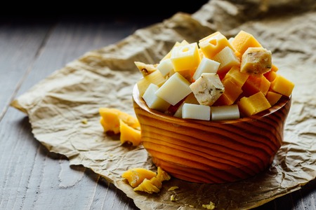 Wooden bowl with pieces of different holland hard cheeseの写真素材