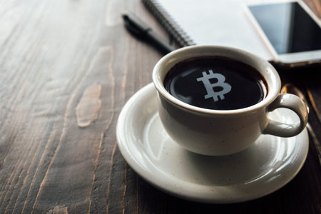 Bitcoin symbol on top of coffee surface. Businessman coffee breakの写真素材
