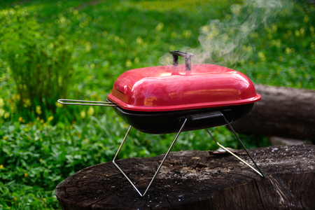 Charcoal BBQ Barbecue Grill  on garden Background. Portable Grillware. Outdoor Cooking Stationの写真素材