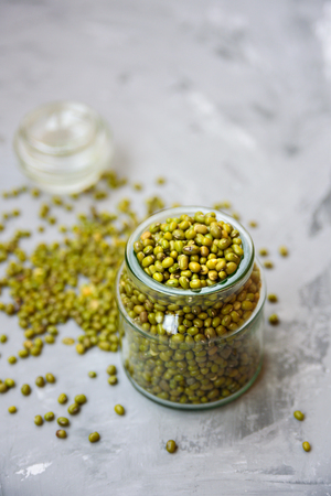 Mung beans in glass jar on grey concrete background. Text spaceの写真素材