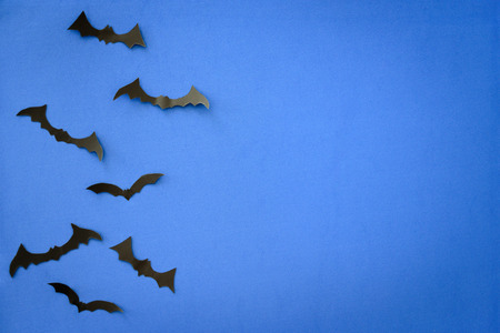 Flying black paper bats on blue background. Halloween. Text spaceの写真素材