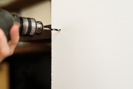 Worker drilling hole in wall with an electric drill. Copy spaceの写真素材