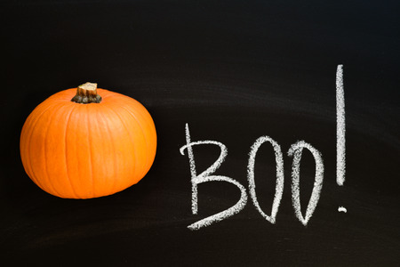 Pumpkin with boo word on black chalk boardの写真素材