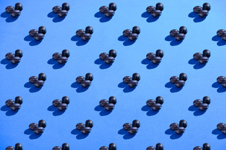 Plums on blue background. Hard light, pattern