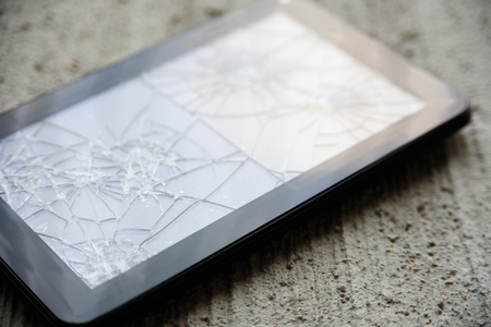 Broken tablen screen close up view on concrete backgroundの写真素材